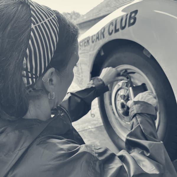 The same wheel with the car lowered, Evie working on it at chest height