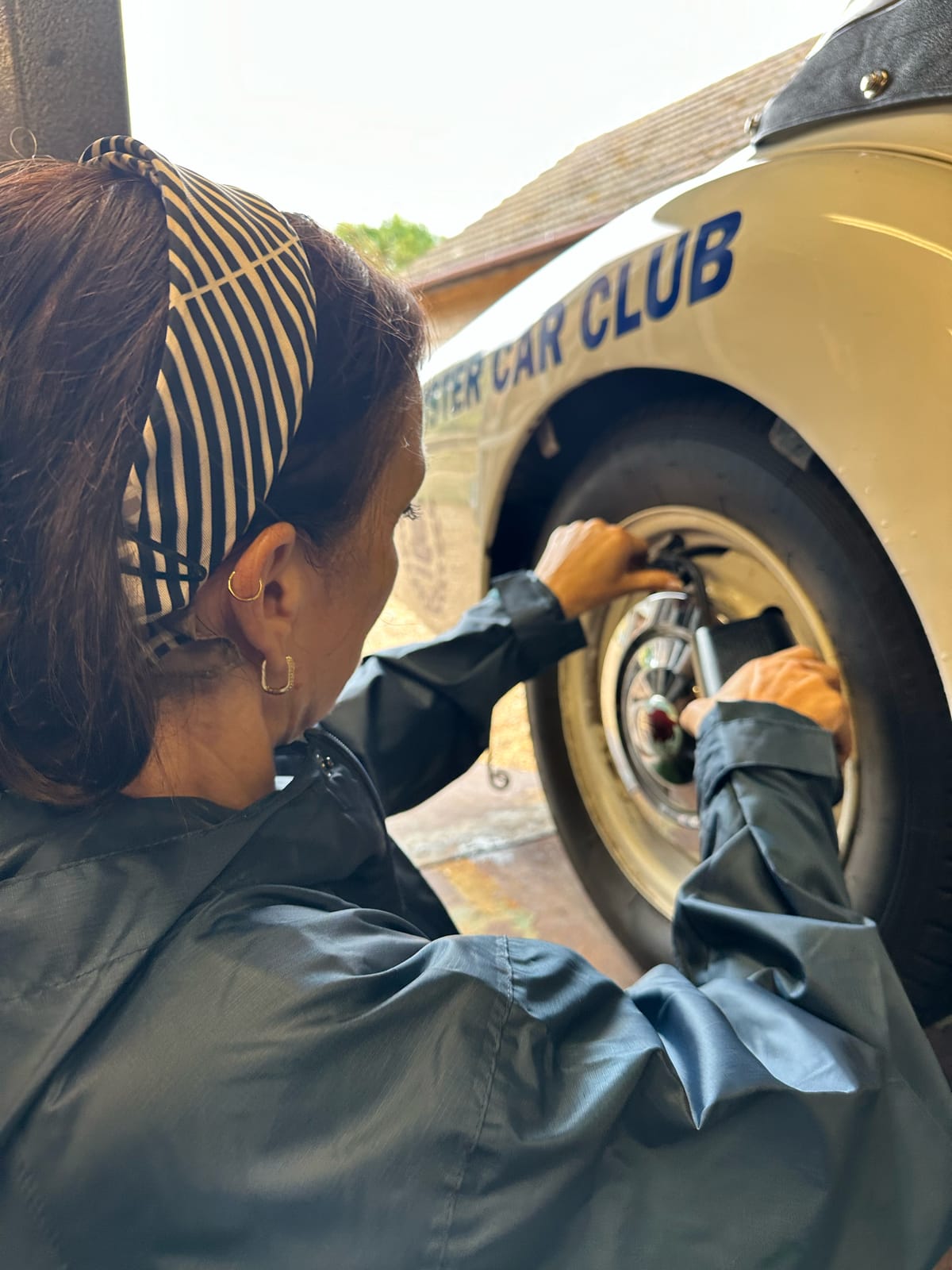 The same wheel with the car lowered, Evie working on it at chest height