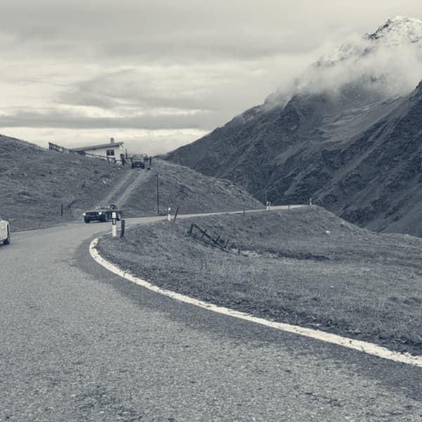 A hairpin on the Umbrail climb, a Triumph ahead on the bend and snow on the peaks above