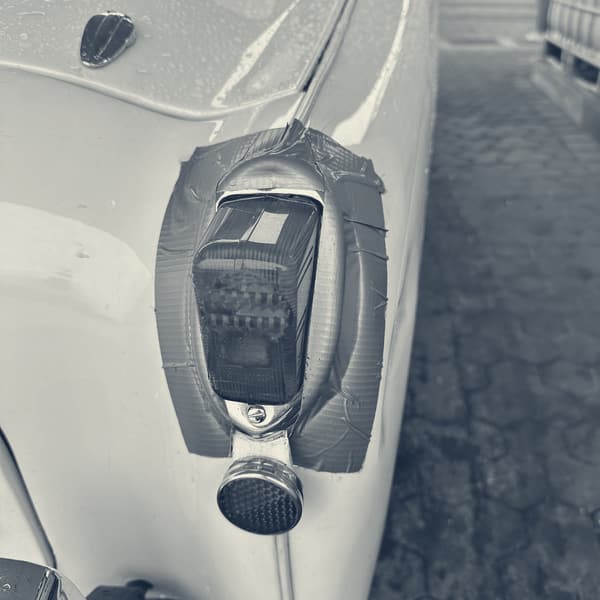 Close up of TS2's rear lamp, its chrome surround held on with a square of grey gaffer tape