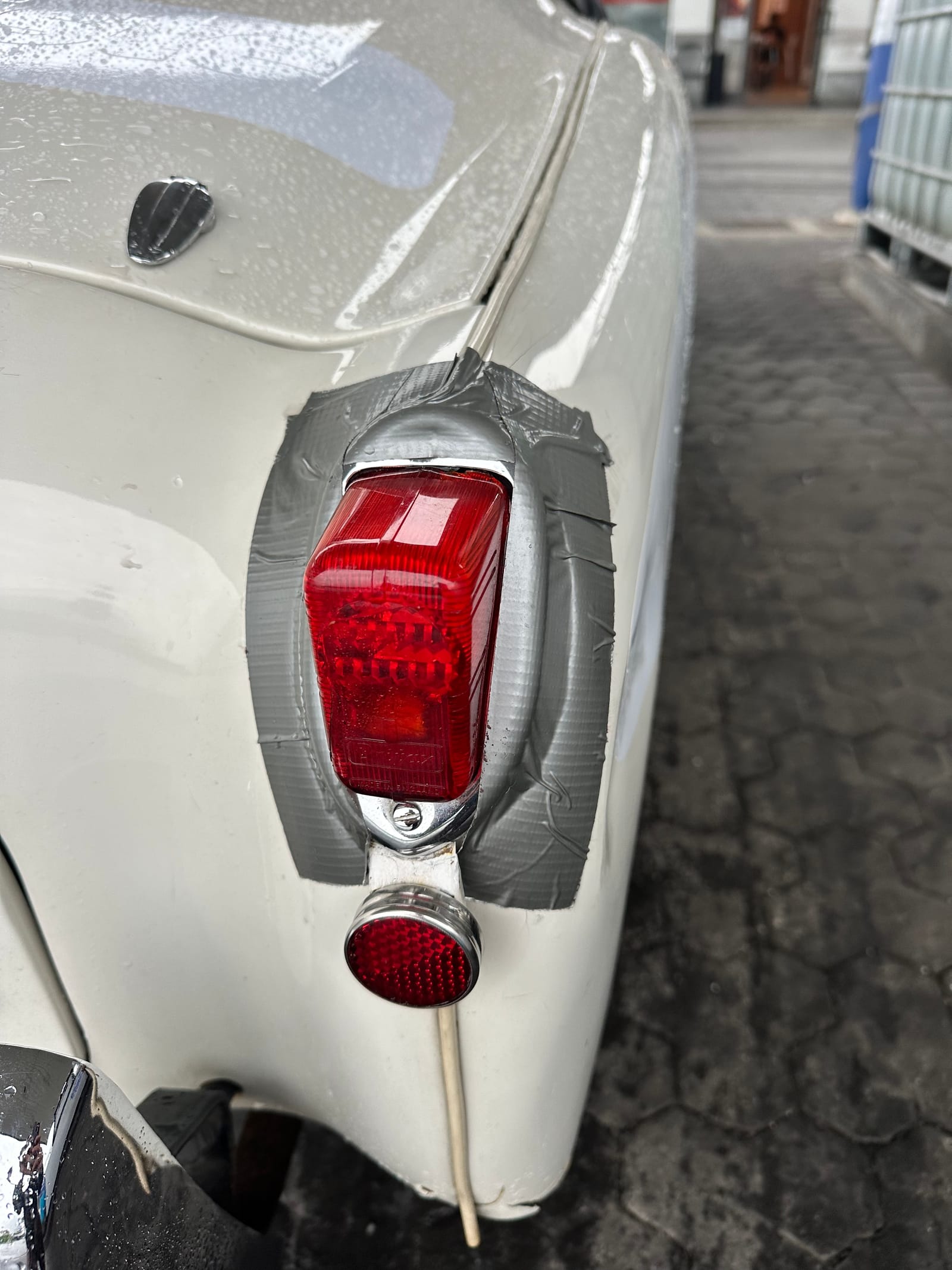 Close up of TS2's rear lamp, its chrome surround held on with a square of grey gaffer tape