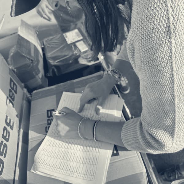 Evie leaning over the same start list, signing her name against the box lid
