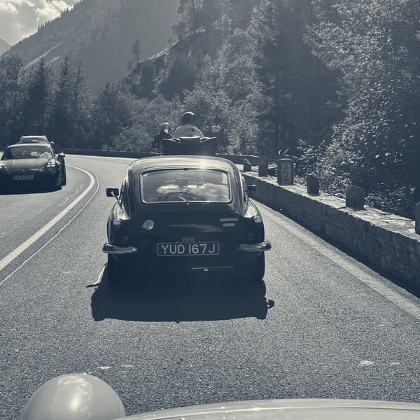The view over TS2's bonnet following a black Triumph GT6 along a walled mountain road