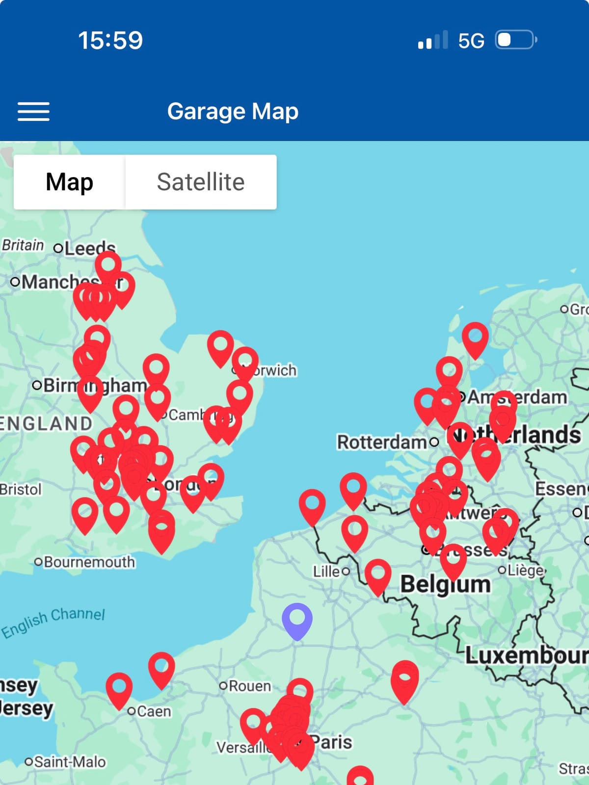 A phone screen headed Garage Map, red pins clustered thickly over England, Belgium and Paris, and a lone blue pin marking us in an empty stretch of northern France