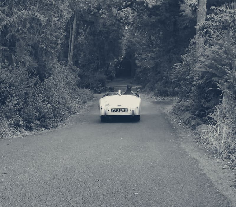 TS2 setting off from home, two up with the hood down, heading away down the lane