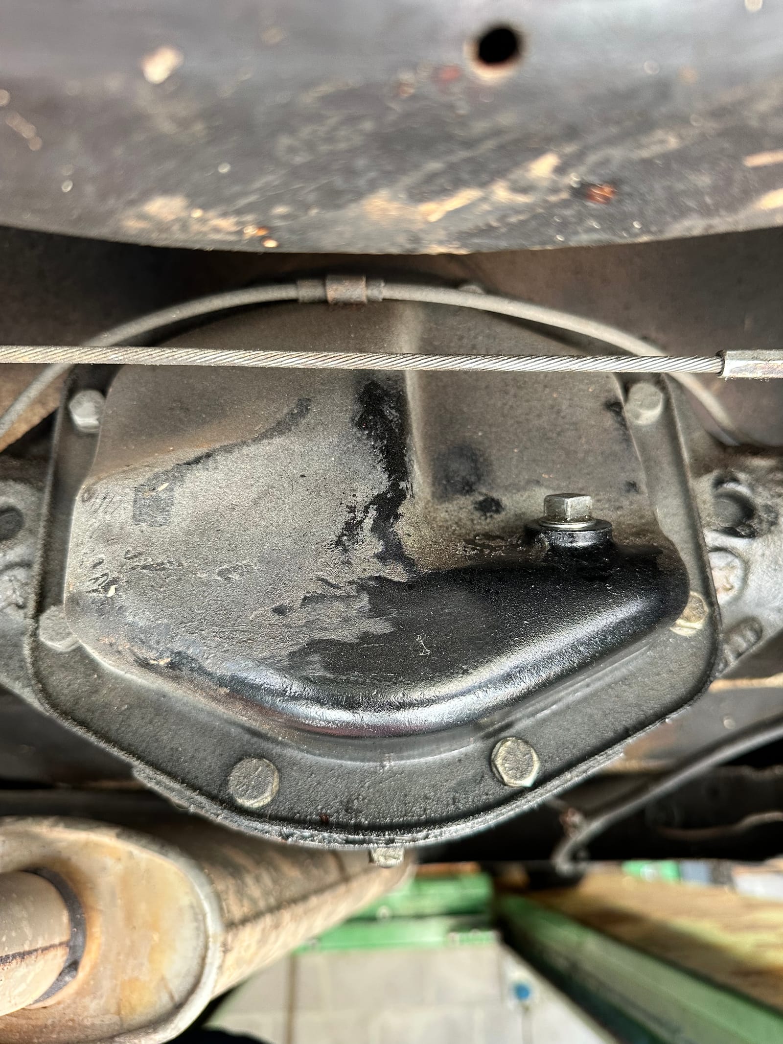 A drain plug and its pan from below, clean and dry around the joint