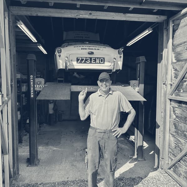 Our host in the doorway of his garage, TS2 raised above and behind him on the four-post lift