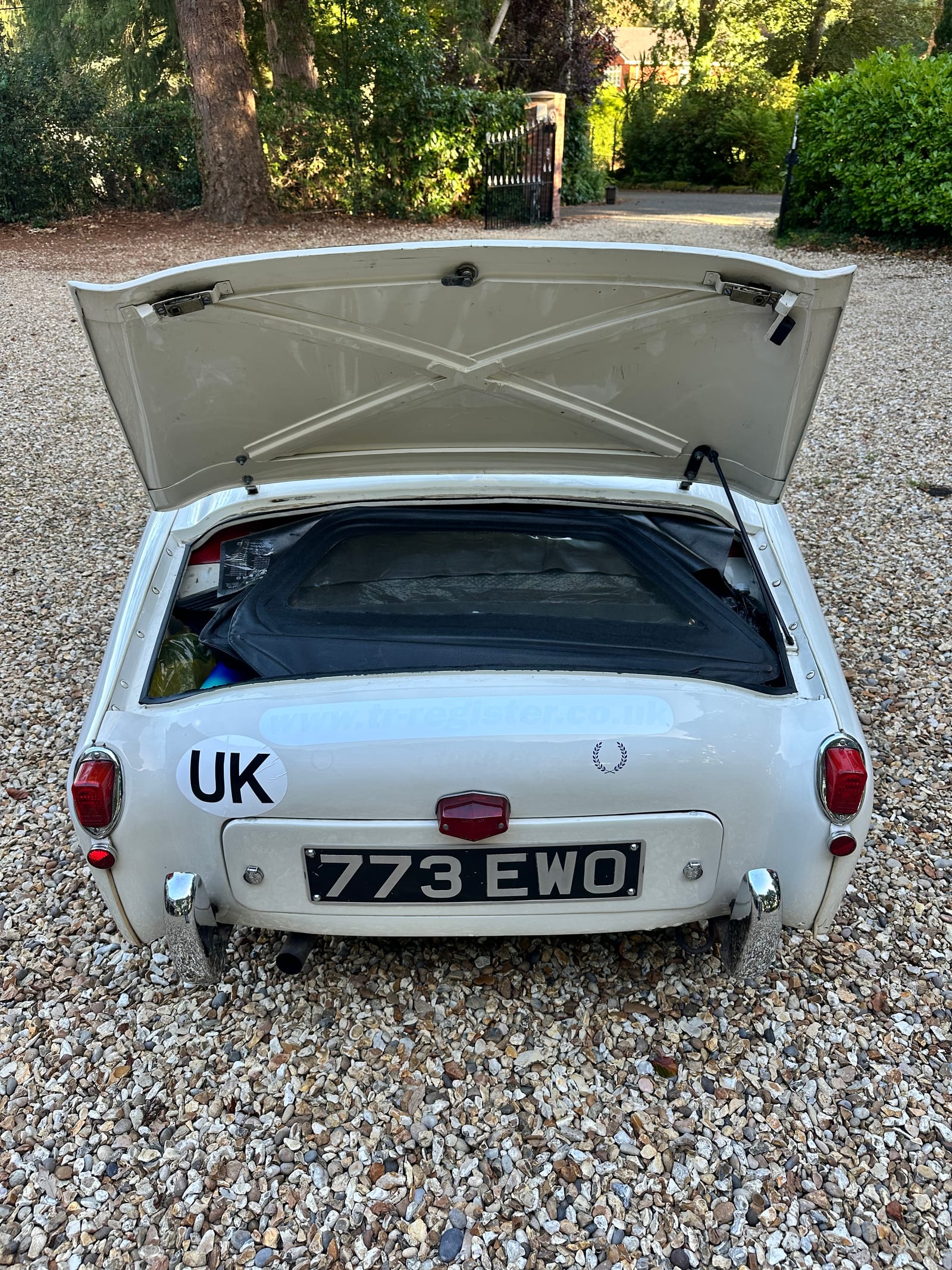 The open boot of TS2 on the gravel drive, packed to the lid with the sidescreens in their black case, spares and tools