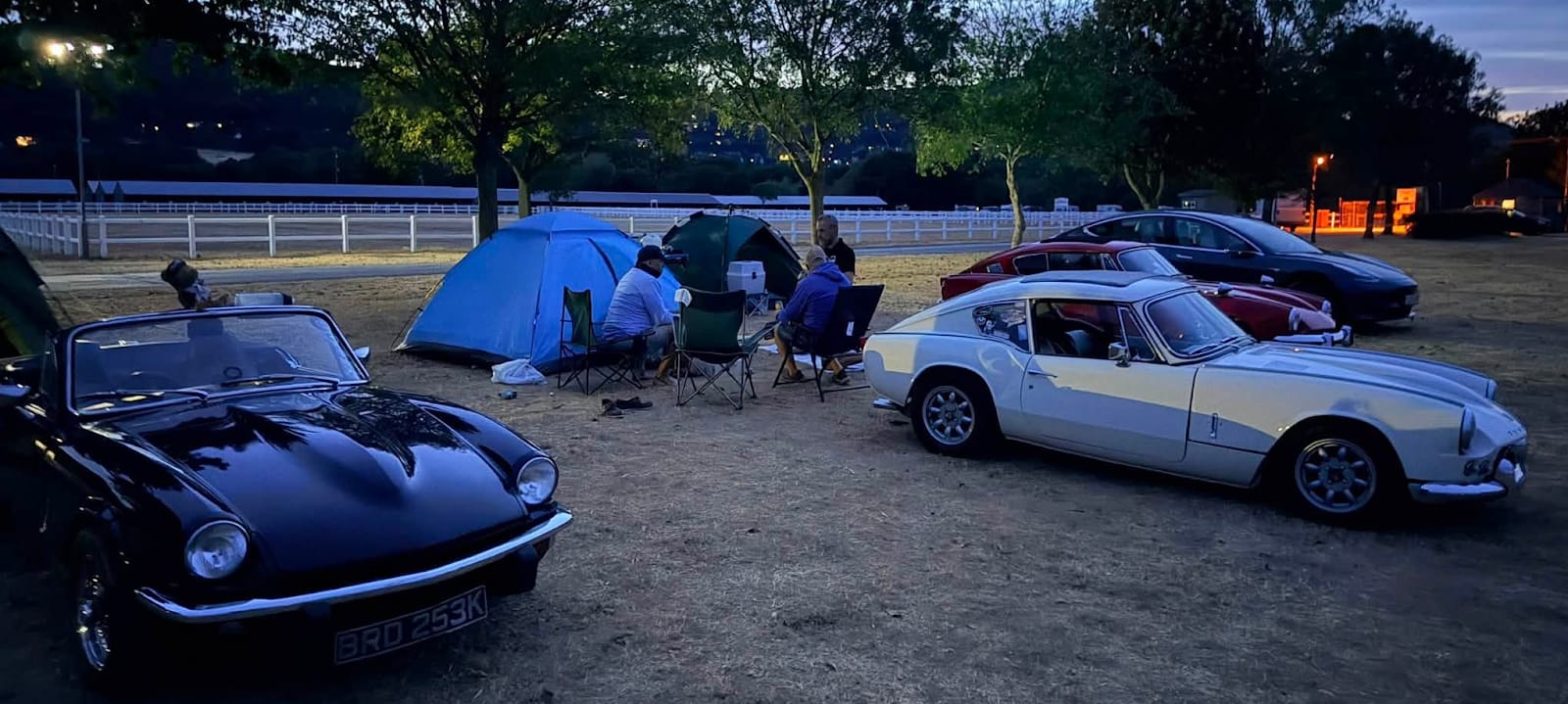 Cars and tents pitched together at dusk at Car Club Fest