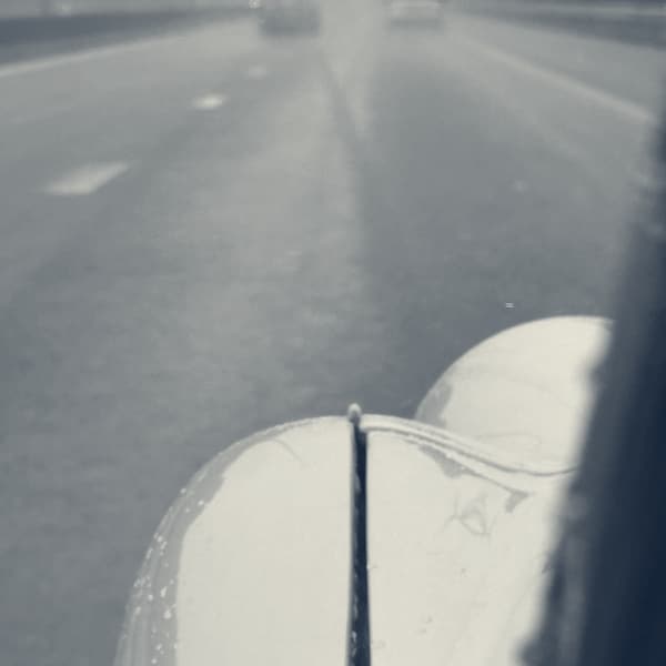 Flat Belgian motorway in heavy spray, two cars ahead almost lost in it, TS2's wet white wing in the foreground