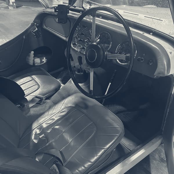 TS2's red leather interior lit by the forecourt lights, big black steering wheel, the dials dark and the seats empty