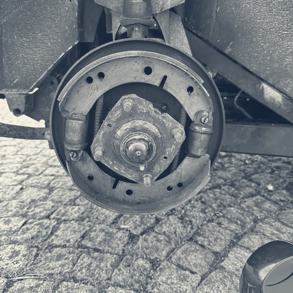 The drum removed, showing the brake shoes, springs and wheel cylinders on the backplate