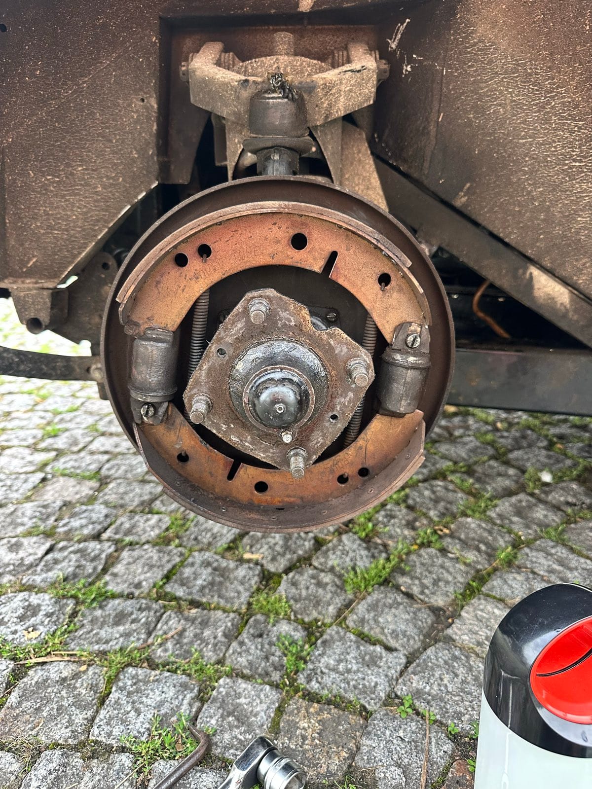The drum removed, showing the brake shoes, springs and wheel cylinders on the backplate