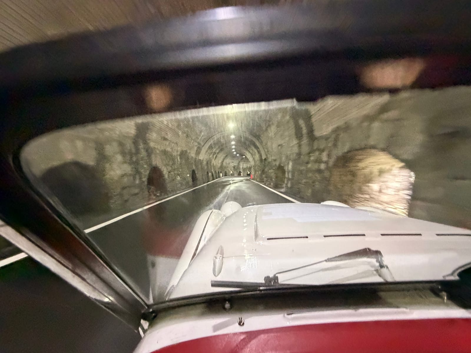 Looking through TS2's windscreen into a rough rock tunnel, a single lamp ahead and the walls close on both sides