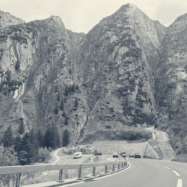 A wider view of the gorge, the road switching back beneath the cliffs and cars small on the bends below