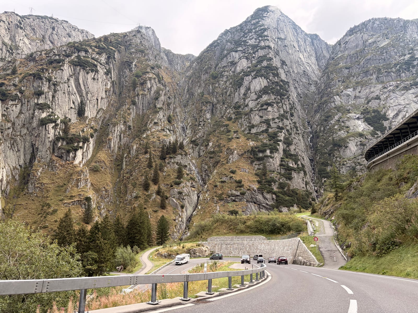 A wider view of the gorge, the road switching back beneath the cliffs and cars small on the bends below