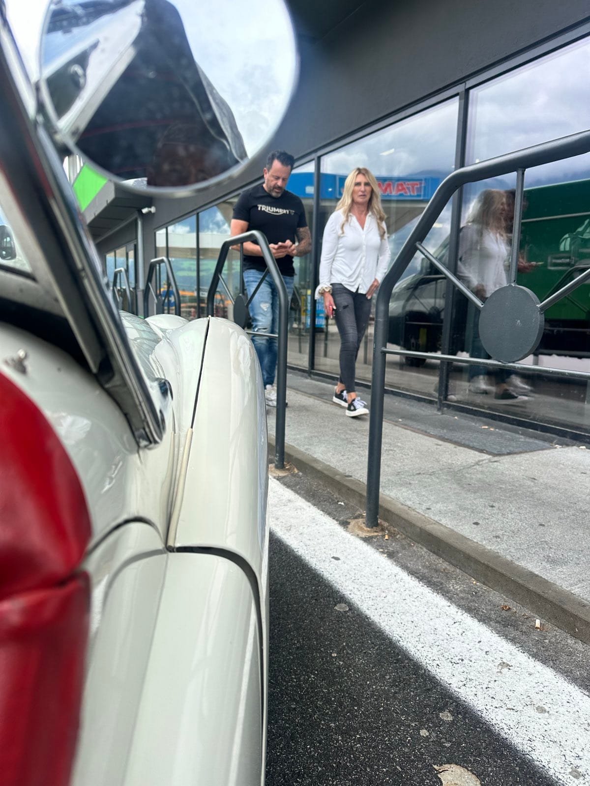 A woman and a man in a Triumph t-shirt standing beside TS2 on the services forecourt