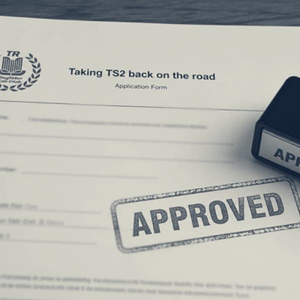 An application form headed “Taking TS2 back on the road”, stamped APPROVED in blue, with the rubber stamp and a pen beside it.