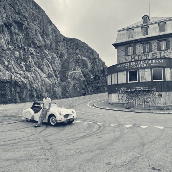 TS2 alone in the empty car park below the Hotel Belvédère on the Furka, Andy sitting on her wing, tyre marks on the tarmac