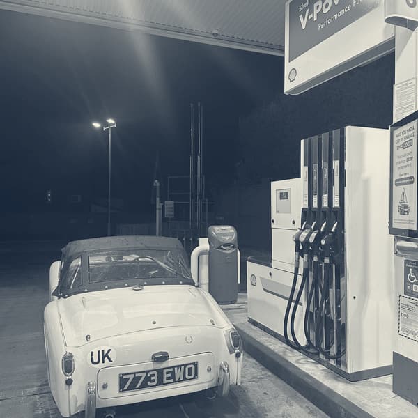 TS2 from behind on a floodlit forecourt at night, UK plate and 773 EWO under the Shell V-Power canopy, everything else black