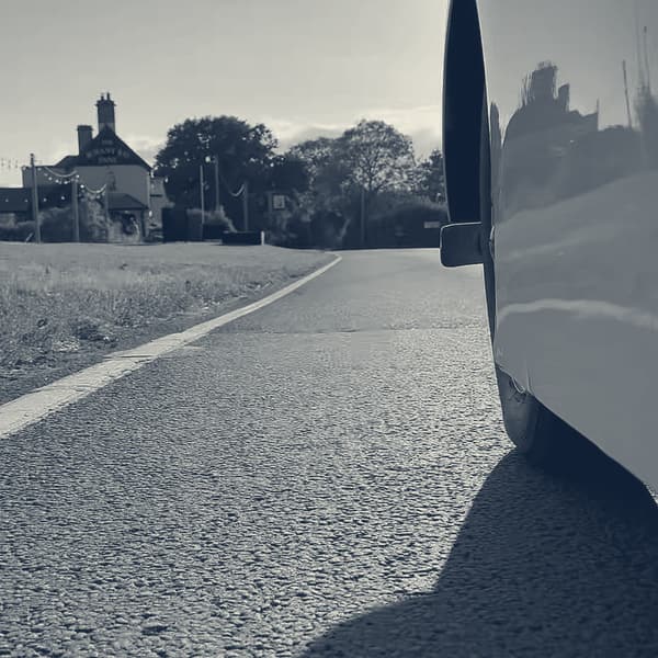 A frame from the 360 camera: low beside TS2's front wing, road and hedgerow running past