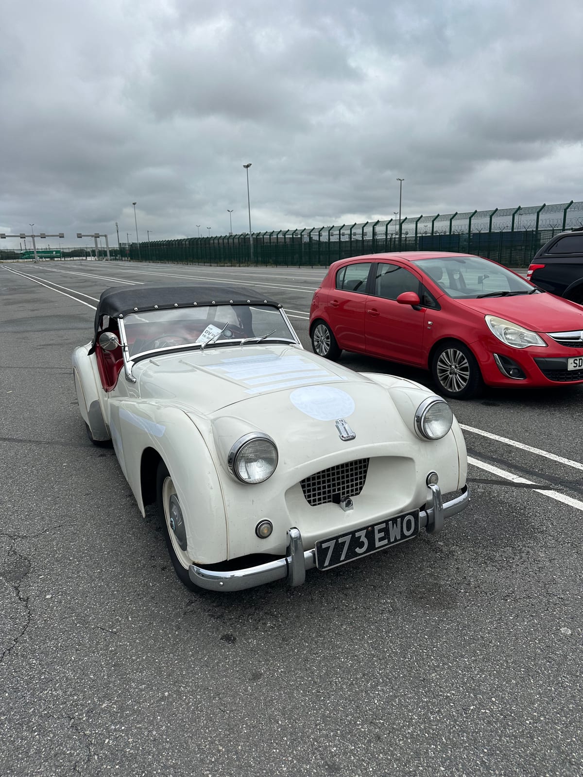 TS2 with her hood up, parked alone in the empty marshalling lanes at Dunkirk under a heavy grey sky, port fencing behind