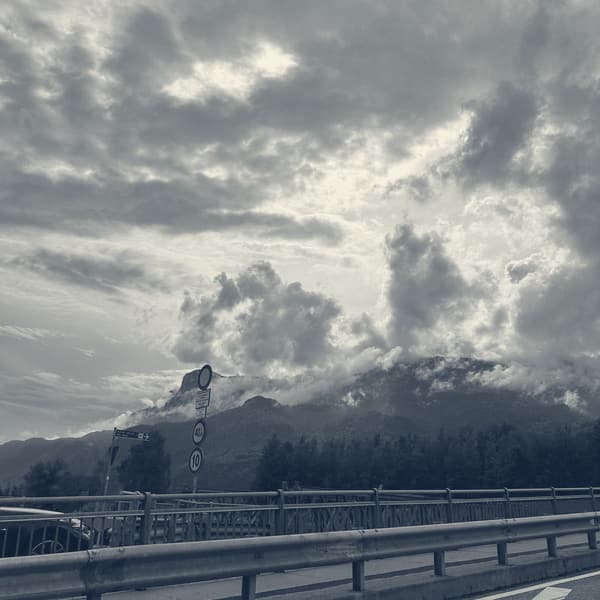 Heavy cloud piled over the mountains, seen from the motorway across the crash barrier