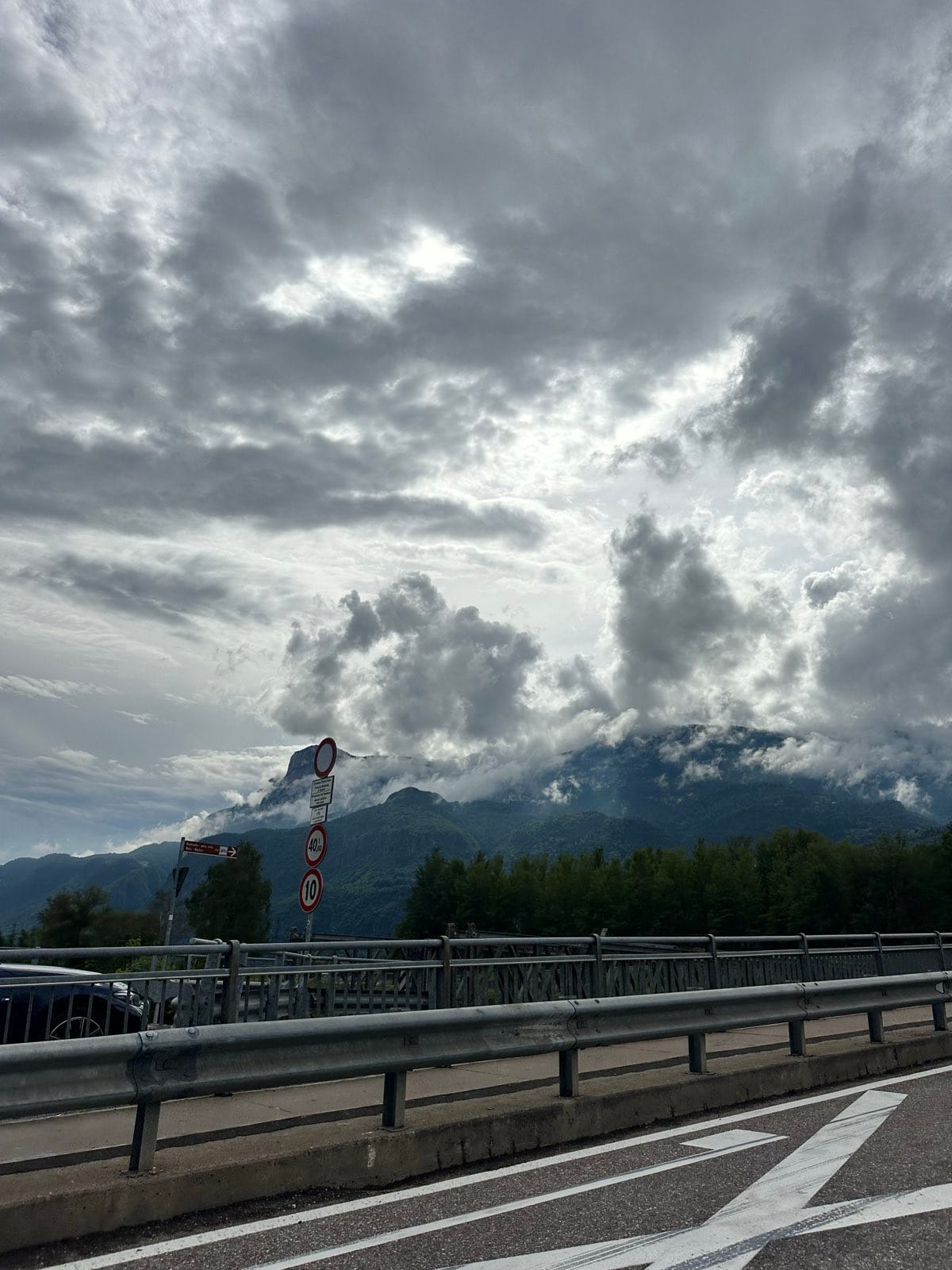 Heavy cloud piled over the mountains, seen from the motorway across the crash barrier